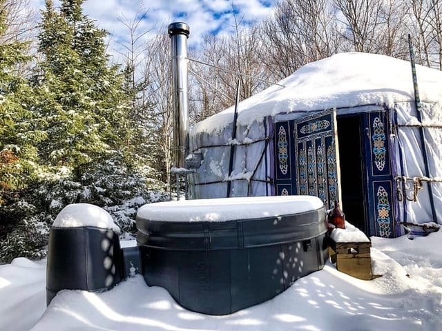 A circular tent with an ornate door covered in snow