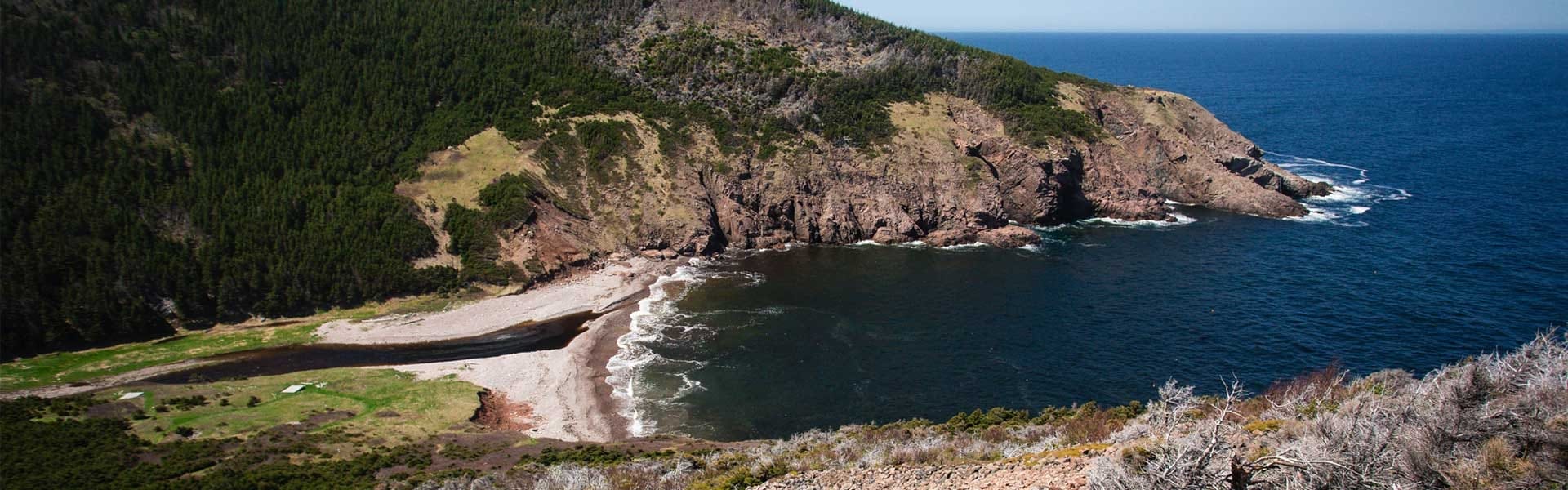 A small beach sits between two rocky coasts