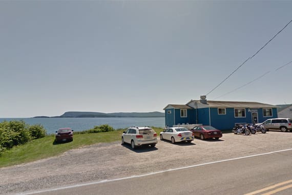 Cars parked outside a restaurant overlooking the ocean