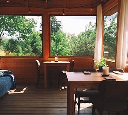 The interior of a sun room with a couch and two tables