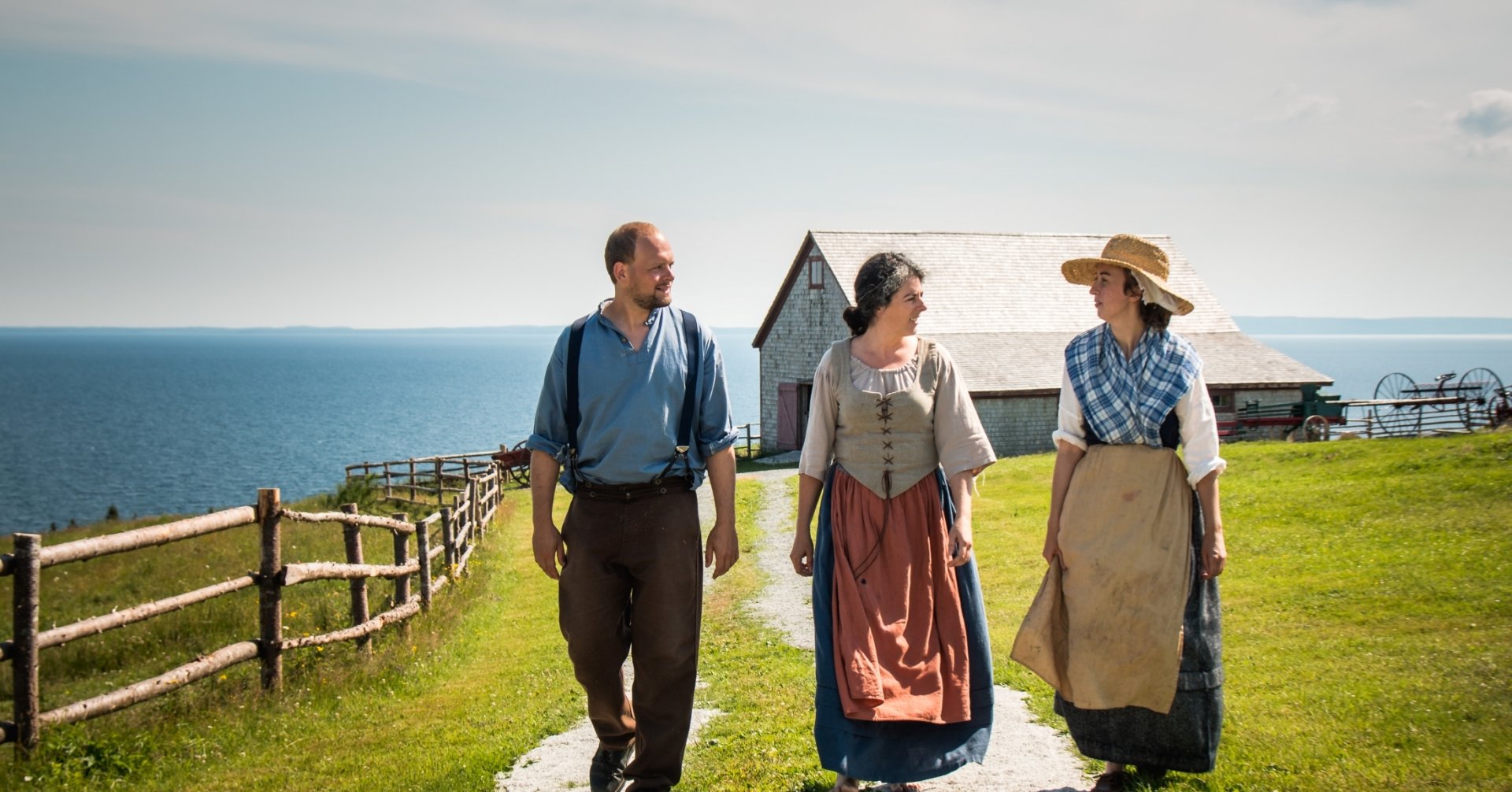 three Cape Bretoners in historic clothing walk outside
