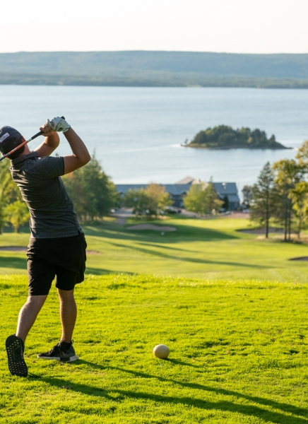 golfer makes a shot by the ocean on cape breton island