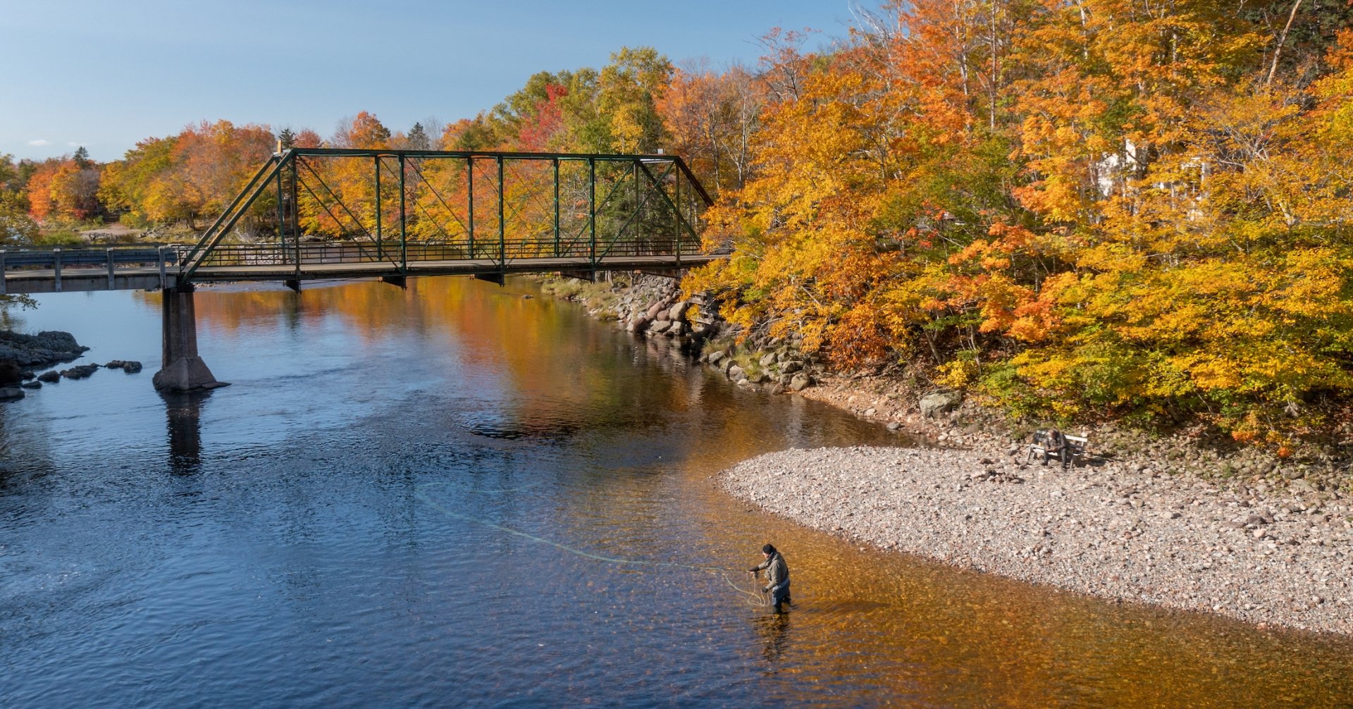 An angler fishes for salmon at the Ross Bridge along the Margaree River in the fall.