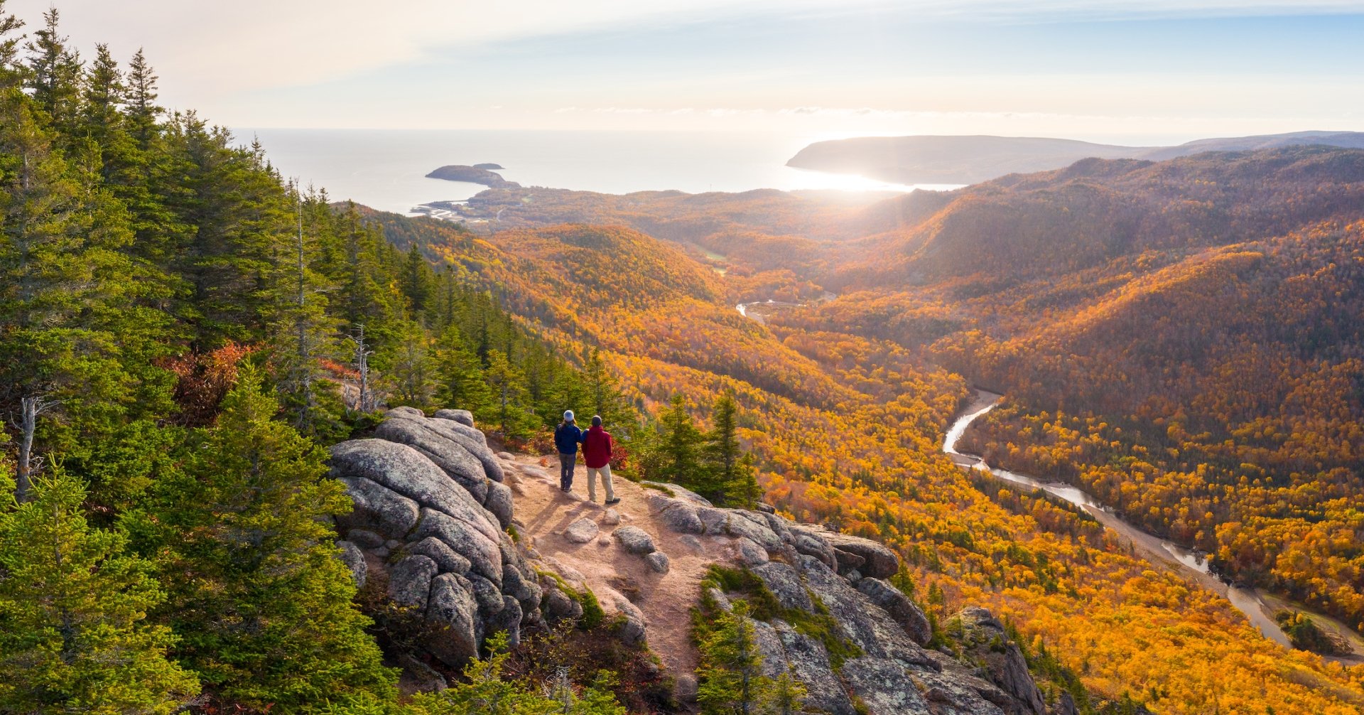 Two hikers enjoy a sunset from the top of Franey Mountain in the fall